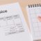Factura con desglose de IVA y dedo señalando un día en un calendario sin fechas