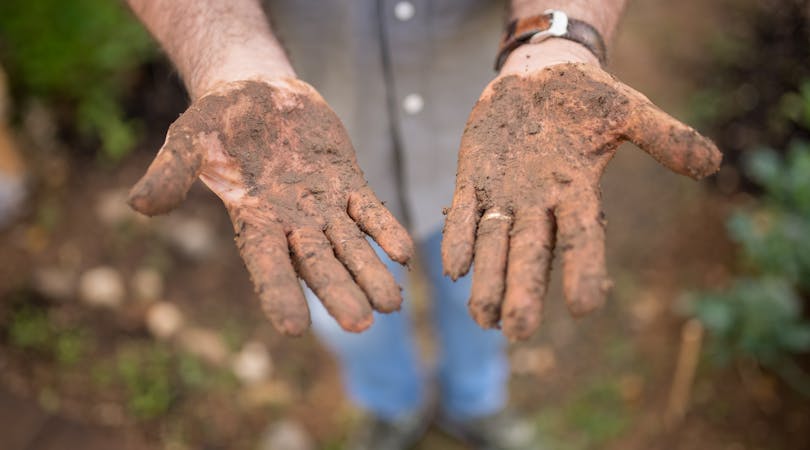 mano manchada de barro por ayudar en la Dana